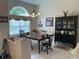 Traditional dining room with large window, chandelier, and beautiful black china cabinet at 19903 Sw 97Th Ln, Dunnellon, FL 34432