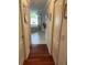 Hallway with wood floors leading to a bright bathroom with bathtub and shower at 19903 Sw 97Th Ln, Dunnellon, FL 34432