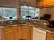 Open kitchen with granite counters and stainless sink overlooking a sparkling pool at 19903 Sw 97Th Ln, Dunnellon, FL 34432