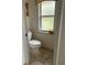 This half bathroom has a neutral color scheme and a window for natural light at 19903 Sw 97Th Ln, Dunnellon, FL 34432