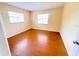 Bedroom showcasing hardwood floors, two windows, and neutral paint at 2146 Ne 10Th St, Ocala, FL 34470