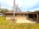 Back of the home featuring newer vinyl siding, brick paver patio, and mature trees at 2146 Ne 10Th St, Ocala, FL 34470