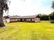 Charming home with a two-car garage, brick accents, well-manicured lawn, and a mature shade tree at 2146 Ne 10Th St, Ocala, FL 34470