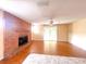 Cozy living room featuring a brick fireplace, hardwood floors, and a ceiling fan at 2146 Ne 10Th St, Ocala, FL 34470