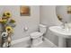 Elegant powder room featuring a pedestal sink, neutral tones, and stylish decorative touches at 3920 Se 7Th Ave, Ocala, FL 34480