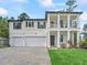 Inviting two-story home featuring a three-car garage, charming front porch, and manicured landscaping at 3920 Se 7Th Ave, Ocala, FL 34480