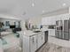 Open concept kitchen boasts stainless steel appliances, an island with a sink, and opens to the living area at 3920 Se 7Th Ave, Ocala, FL 34480