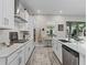 Bright, white kitchen featuring modern appliances, marble counters, and stainless steel accents with an island at 3920 Se 7Th Ave, Ocala, FL 34480