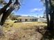 A large backyard featuring mature trees with a concrete patio at 416 Marion Oaks Crse, Ocala, FL 34473