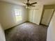 Carpeted bedroom featuring a ceiling fan, closet, and a window providing natural light at 416 Marion Oaks Crse, Ocala, FL 34473