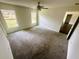 Spacious bedroom with plush carpeting, ceiling fan, and large windows at 416 Marion Oaks Crse, Ocala, FL 34473