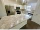 Bright kitchen with stainless steel appliances, white cabinets, and large island with stone countertop at 416 Marion Oaks Crse, Ocala, FL 34473