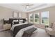 This bedroom is furnished with a king bed, neutral colors, a ceiling fan, and natural lighting from the windows at 4497 Nw 54Th Ter, Ocala, FL 34482