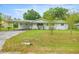 Inviting one-story home featuring a carport, a cozy front porch, and a well-kept lawn at 4516 Ne 8Th St, Ocala, FL 34470
