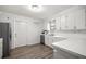 Well-lit kitchen featuring white countertops and cabinets, a stainless-steel refrigerator, and wood flooring at 4516 Ne 8Th St, Ocala, FL 34470