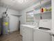 Laundry room with washer, dryer, water heater, and storage shelves at 4516 Ne 8Th St, Ocala, FL 34470