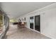 Long enclosed patio with tile flooring, chairs, and access to backyard and pool at 4516 Ne 8Th St, Ocala, FL 34470