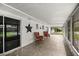 Enclosed patio area with tiled floor, chairs, and view of backyard at 4516 Ne 8Th St, Ocala, FL 34470