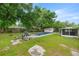 Inviting backyard with a covered pool, lush greenery, and a storage shed, perfect for outdoor enjoyment and relaxation at 4516 Ne 8Th St, Ocala, FL 34470