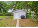 View of a well-maintained storage shed with a clean white facade, complemented by a lush green lawn at 4516 Ne 8Th St, Ocala, FL 34470