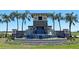 Community entrance featuring stone details, water features, and lush landscaping surrounded by palm trees at 4754 Sw 88Th Ln, Ocala, FL 34476