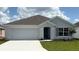 Charming single-story home with a two-car garage, gray exterior, and well-manicured lawn at 4754 Sw 88Th Ln, Ocala, FL 34476
