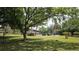 Expansive community lawn with mature trees and amenities, including a pool, creates a park-like setting at 501 Fairways Ln # A, Ocala, FL 34472