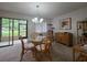 Bright dining room featuring a glass table and sliding glass door to the outdoors at 501 Fairways Ln # A, Ocala, FL 34472