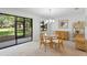 Dining room with a glass table, wicker chairs, a view to the outside through sliding glass doors to a screened porch at 501 Fairways Ln # A, Ocala, FL 34472