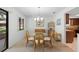 Bright dining area with a glass-top table, wicker chairs, neutral carpet, and views of the neighborhood at 501 Fairways Ln # A, Ocala, FL 34472
