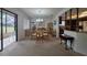 Bright dining room with a chandelier, access to the lanai, and views into the kitchen at 501 Fairways Ln # A, Ocala, FL 34472