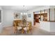 Dining area featuring a glass-top table with wicker chairs, a modern chandelier, and a view of the kitchen at 501 Fairways Ln # A, Ocala, FL 34472
