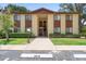 Two-story condo building featuring a beige facade with brown accents, stairs to the second level, and manicured landscaping at 501 Fairways Ln # A, Ocala, FL 34472