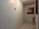 Hallway featuring tile flooring, a thermostat, and decorative artwork on the wall at 501 Fairways Ln # A, Ocala, FL 34472