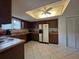 Well-lit kitchen featuring wood cabinets, white appliances, and tiled flooring at 501 Fairways Ln # A, Ocala, FL 34472