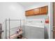 Functional laundry room with washer, dryer, storage cabinets and open shelving at 501 Fairways Ln # A, Ocala, FL 34472