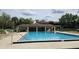 Community pool surrounded by chairs, featuring a gazebo and lush trees around the perimeter at 501 Fairways Ln # A, Ocala, FL 34472