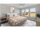 Bright bedroom featuring an artistic painting, ceiling fan, and an array of windows that provide ample sunlight at 5567 Nw 45Th Ln, Ocala, FL 34482
