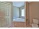 Bright bathroom featuring a soaking tub, linen closet, and toilet at 5590 Sw 172Nd Loop, Ocala, FL 34473