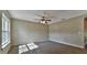 Neutral living room with gray carpet, ceiling fan, and light from the bright window at 5590 Sw 172Nd Loop, Ocala, FL 34473