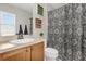 This bathroom has a wooden vanity, decorative shower curtain, and inspirational wall art at 5781 Sw 39Th St, Ocala, FL 34474
