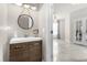 Modern powder room featuring a stylish vanity, round mirror, and neutral decor at 5781 Sw 39Th St, Ocala, FL 34474