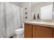 Well-lit bathroom featuring a shower with patterned curtain and vanity with storage at 5781 Sw 39Th St, Ocala, FL 34474