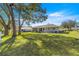 Green lawn, mature trees and patio area with outdoor seating at 5877 Sw 103Rd St, Ocala, FL 34476
