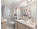 Well-lit bathroom featuring a large vanity, sink, and shower-tub combo at 5877 Sw 103Rd St, Ocala, FL 34476