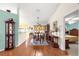 Elegant dining area featuring hardwood floors and views into the kitchen and a bedroom at 5877 Sw 103Rd St, Ocala, FL 34476
