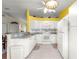 The kitchen features white appliances, white cabinets, tile floor, and yellow accent wall at 5877 Sw 103Rd St, Ocala, FL 34476