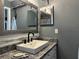 Bathroom featuring modern gray walls, granite countertops, a vessel sink, and a decorative mirror at 6082 Sw 104Th St, Ocala, FL 34476