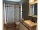 Updated bathroom with vanity, granite counters, stylish mirror, and shower with patterned curtain at 6082 Sw 104Th St, Ocala, FL 34476
