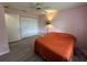 Comfortable bedroom with an orange bed, closet, and a lamp with pink walls at 6082 Sw 104Th St, Ocala, FL 34476